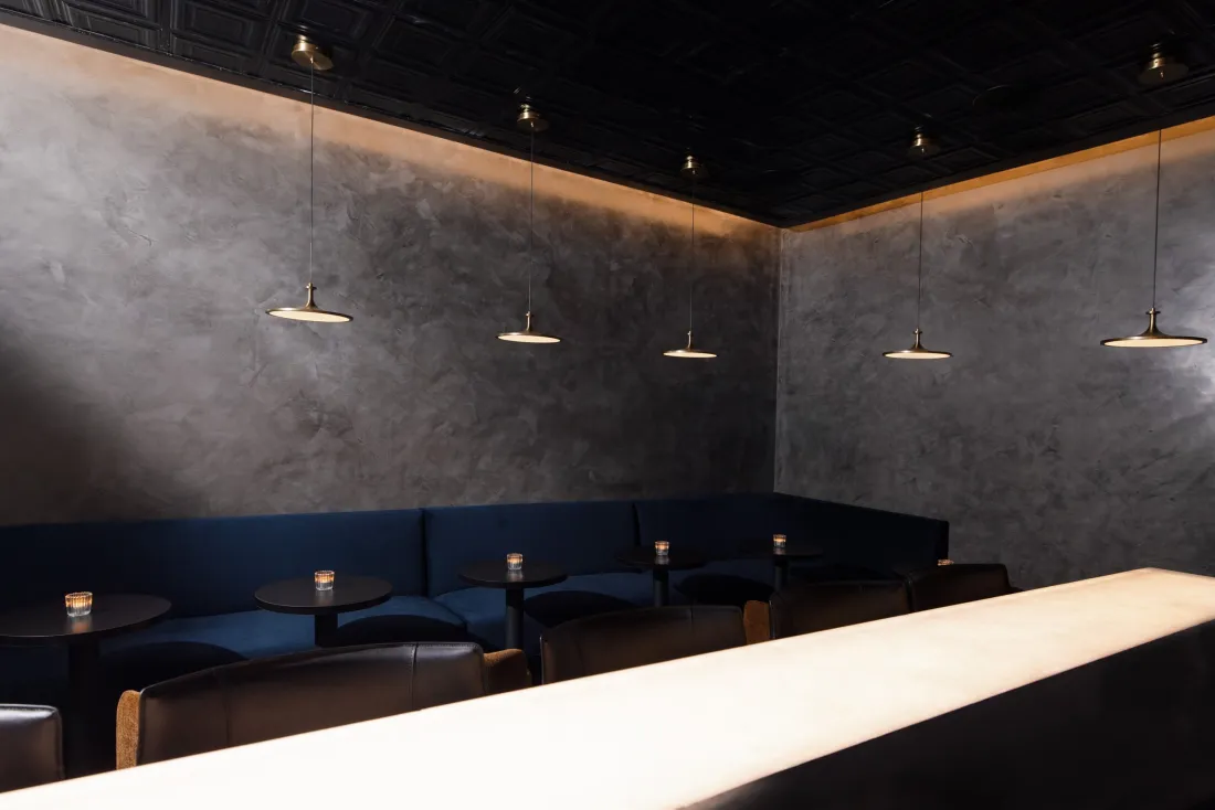 Nightcap, the speakeasy at Class Act: plaster walls and a row of pendant lights.