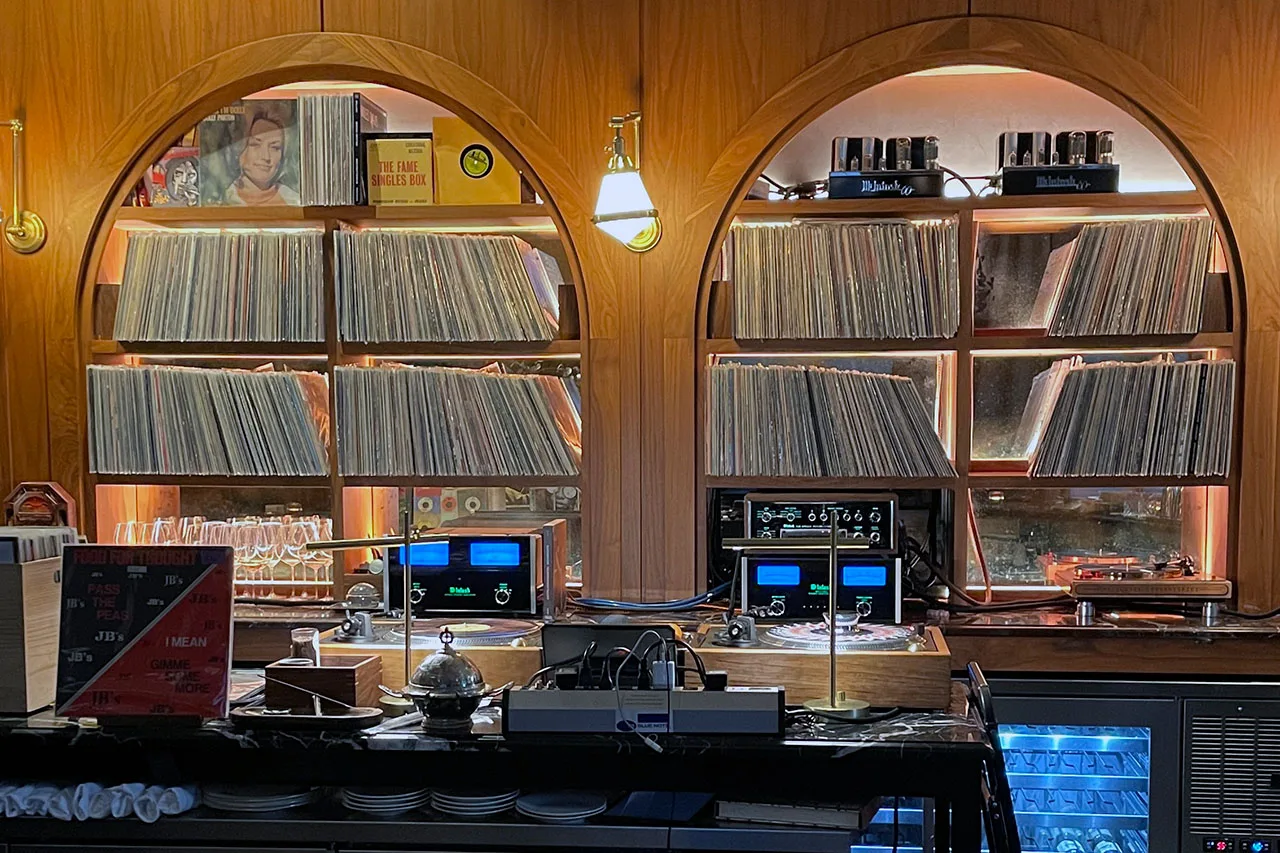 McIntosh amplifiers on walnut record shelves at a bar.