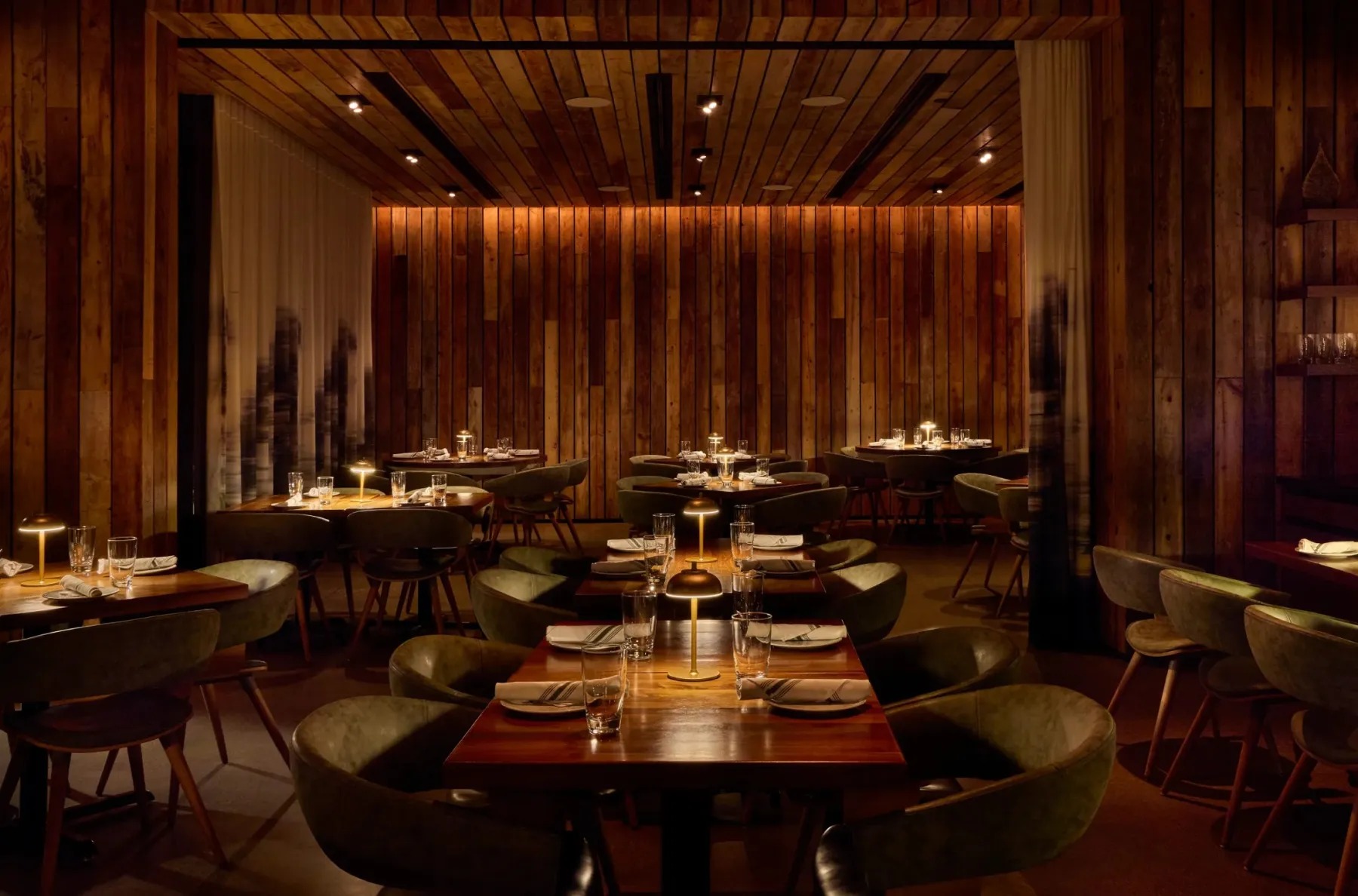 Sophia Steak: dark wood, low table lamps and warm light.
